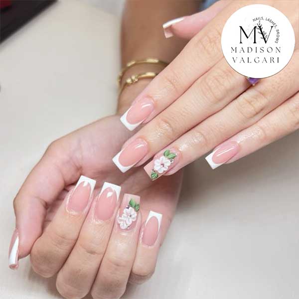 Classic French manicure with three dimensional white floral accent nails